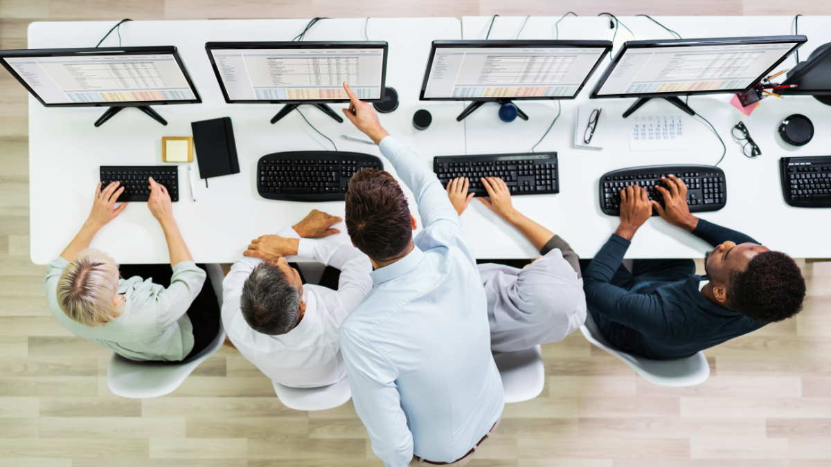 Employees sitting at a row of computers being trained to use AI
